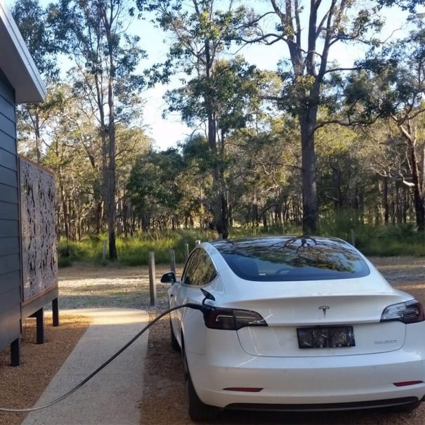 A Tesla vehicle getting charged alongside the chalet.